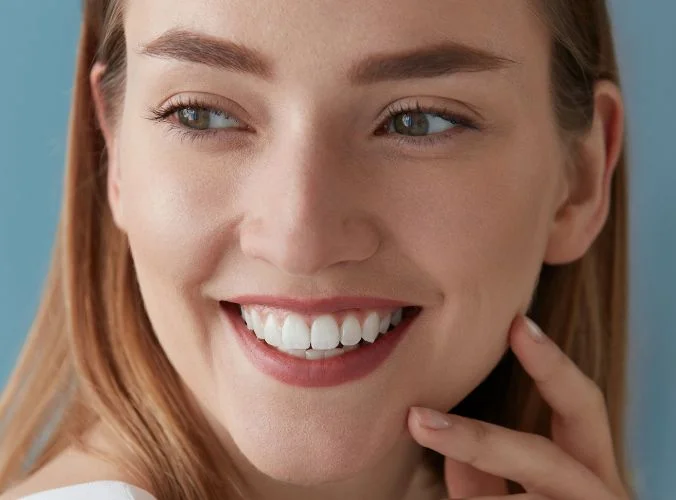 Mujer joven sonriendo en representación de los tratamientos de blanqueamiento dental en Málaga y carillas dentales en málaga de la clínica dental Avilés DDC, dentistas en Málaga.