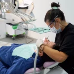 Higienista dental haciendo una exploración a un paciente. Imagen representativa del post sobre la relación entre la diabetes y caries dental publicado por la clínica dental Avilés Digital Dental Clinic, dentistas en Málaga.